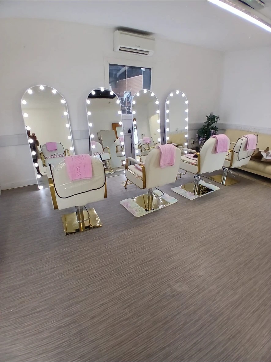 Monica's salon with lit mirrors and gold chairs